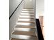 Staircase with wood treads, painted white risers, and a black handrail, leading to the second floor at 5423 Sweetwater Terrace Cir, Tampa, FL 33634