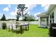 The backyard contains an outdoor dining area, manicured lawn, and a grill for outdoor cooking, along with a fence at 5546 Spanish Moss Cv, Bradenton, FL 34203