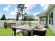 Backyard includes manicured lawn, outdoor dining set, lounge furniture, privacy fencing, and covered patio area at 5546 Spanish Moss Cv, Bradenton, FL 34203