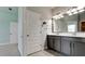 Modern bathroom with gray cabinets, double sinks, stylish fixtures and a large vanity mirror at 5546 Spanish Moss Cv, Bradenton, FL 34203