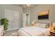 Bright bedroom featuring modern lighting, plush bedding and a mounted TV above the bed at 5546 Spanish Moss Cv, Bradenton, FL 34203