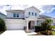 Charming two-story home features a red front door, attached garage, and well-manicured landscaping at 5546 Spanish Moss Cv, Bradenton, FL 34203