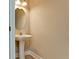 Powder room features a pedestal sink with an oval mirror and modern lighting at 5546 Spanish Moss Cv, Bradenton, FL 34203