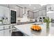 Well-lit kitchen with stainless steel refrigerator, gray cabinets, and a quartz island at 5546 Spanish Moss Cv, Bradenton, FL 34203