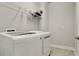 Bright laundry room features a modern washer and dryer, complemented by shelving for organized storage at 5546 Spanish Moss Cv, Bradenton, FL 34203