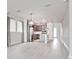 Open-concept living room features modern light fixtures and flows into the kitchen with gray cabinetry at 5546 Spanish Moss Cv, Bradenton, FL 34203