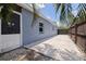 Blue exterior showcasing a patio area with palm trees and a wooden fence at 5690 82Nd N Ter, Pinellas Park, FL 33781