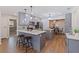 Modern kitchen with grey cabinets, stainless steel appliances, and an island with seating, seamlessly connected to dining area at 5690 82Nd N Ter, Pinellas Park, FL 33781