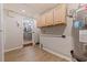 Bright Laundry room with a view into the kitchen, wood floors, and plentiful storage at 5690 82Nd N Ter, Pinellas Park, FL 33781