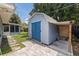 Exterior of the backyard shed with double blue doors and a small brick covered area at 5690 82Nd N Ter, Pinellas Park, FL 33781