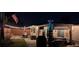 Nighttime view of the backyard with string lights, covered patio with furniture, and a neatly fenced yard at 5936 13Th Ave, New Port Richey, FL 34652