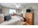 Cozy bedroom with wood-look floors, ceiling fan, dresser, and large window at 5936 13Th Ave, New Port Richey, FL 34652