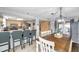 Open-concept dining area with a rustic table and a breakfast bar with modern stools at 5936 13Th Ave, New Port Richey, FL 34652