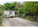 This property features a spacious driveway surrounded by mature trees and landscaping at 6006 Axelrod Rd, Tampa, FL 33634