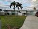 Charming single-story home with lush green lawn and mature trees at 649 Normandy Rd, Madeira Beach, FL 33708