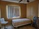 Small bedroom with tan walls, tiled floor, a twin bed, and a bright window at 6818 59Th St, N., Pinellas Park, FL 33781