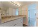 Bathroom featuring granite countertops, white cabinets, and a large vanity mirror with modern lighting at 6826 Stones Throw N Cir # 11308, St Petersburg, FL 33710