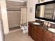 Bathroom featuring a double vanity with a decorative mirror and a walk-in shower at 7031 Drury St, Tampa, FL 33635