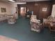 Cozy living room features green carpet, floral furniture, and classic wood paneling at 802 Brandy Wine Dr # 802, Largo, FL 33771