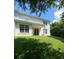 A lush green backyard with a large, pristine lawn, back patio, and sliding glass doors leading to a white two-story home at 8320 Manor Club Cir # 4, Tampa, FL 33647