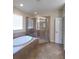 A bathroom featuring a soaking tub, glass shower, and neutral tile flooring at 8320 Manor Club Cir # 4, Tampa, FL 33647