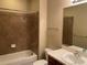 Bathroom featuring a single vanity, a shower-tub combo, and neutral-colored tile at 8320 Manor Club Cir # 4, Tampa, FL 33647
