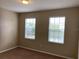 A cozy bedroom with neutral walls, carpet flooring, and two windows that let in natural light at 8320 Manor Club Cir # 4, Tampa, FL 33647