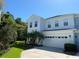 Two-story home with a two-car garage, well-maintained lawn, and mature trees at 8320 Manor Club Cir # 4, Tampa, FL 33647
