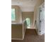 Hallway with brown carpet, natural light, and white trim leading to staircase with arched window view at 8320 Manor Club Cir # 4, Tampa, FL 33647