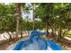 A winding blue water slide nestled among lush trees offers a fun, playful community amenity at 8320 Manor Club Cir # 4, Tampa, FL 33647