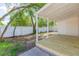 Back porch with white columns, a lattice trim, and a wooden floor offering views of the backyard at 9445 Cardy St, New Port Richey, FL 34654