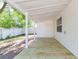 A view of the back porch with wood floors, leading to the backyard with white fencing and some tree coverage at 9445 Cardy St, New Port Richey, FL 34654