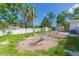 View of backyard, featuring a storage shed, fencing, trees, and a partially paved area with patchy grass at 9445 Cardy St, New Port Richey, FL 34654