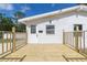 Bright white home with a new wood deck perfect for relaxing, complemented by a freshly painted front door at 9445 Cardy St, New Port Richey, FL 34654