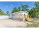 Charming single-story home with a new wooden deck, white picket fence and fresh white siding at 9445 Cardy St, New Port Richey, FL 34654