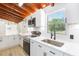 Bright kitchen with quartz counters, stainless appliances, and view to the backyard at 9445 Cardy St, New Port Richey, FL 34654