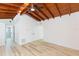 Spacious living area showcasing wood floors, painted walls, and a beautiful wood beamed ceiling at 9445 Cardy St, New Port Richey, FL 34654