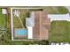 An aerial view showcases the home's layout, including a pool, fire pit, and fenced backyard at 9801 56Th N St, Pinellas Park, FL 33782