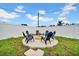 Grassy backyard showcasing a circular fire pit area with chairs for relaxing at 9801 56Th N St, Pinellas Park, FL 33782