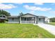 Charming single-story home featuring a well-manicured lawn, freshly painted exterior, and inviting front porch at 9801 56Th N St, Pinellas Park, FL 33782