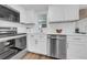 Modern kitchen featuring white cabinets, stainless steel appliances, and quartz countertops at 9801 56Th N St, Pinellas Park, FL 33782