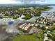 Wide aerial view of the residential neighborhood with lake and surrounding woodland areas at 10196 Seminole Island Dr, Largo, FL 33773