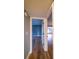 Hallway with wood-look flooring and view of a bedroom with blue walls at 10196 Seminole Island Dr, Largo, FL 33773