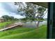 Scenic view of the lake, dock, and mature trees from inside the home at 10196 Seminole Island Dr, Largo, FL 33773