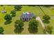 Aerial shot of a two-story home featuring a large lawn, mature trees, and a long driveway leading to the house at 10510 Lithia Estates Dr, Lithia, FL 33547