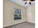 Neutral bedroom featuring gray carpet, a ceiling fan, and a view to trees through a window at 10510 Lithia Estates Dr, Lithia, FL 33547
