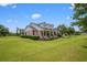 Beautiful house with lush lawn and landscaping; inviting porch with dormer windows above at 10510 Lithia Estates Dr, Lithia, FL 33547