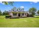 Charming house with dormer windows, a manicured lawn, and mature trees at 10510 Lithia Estates Dr, Lithia, FL 33547