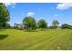 A charming home sits on a large, green lot with mature trees and blue skies above at 10510 Lithia Estates Dr, Lithia, FL 33547
