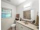Bright bathroom featuring a single sink vanity, a toilet, a shower, and a well-lit mirror at 1116 W Kirby St, Tampa, FL 33604